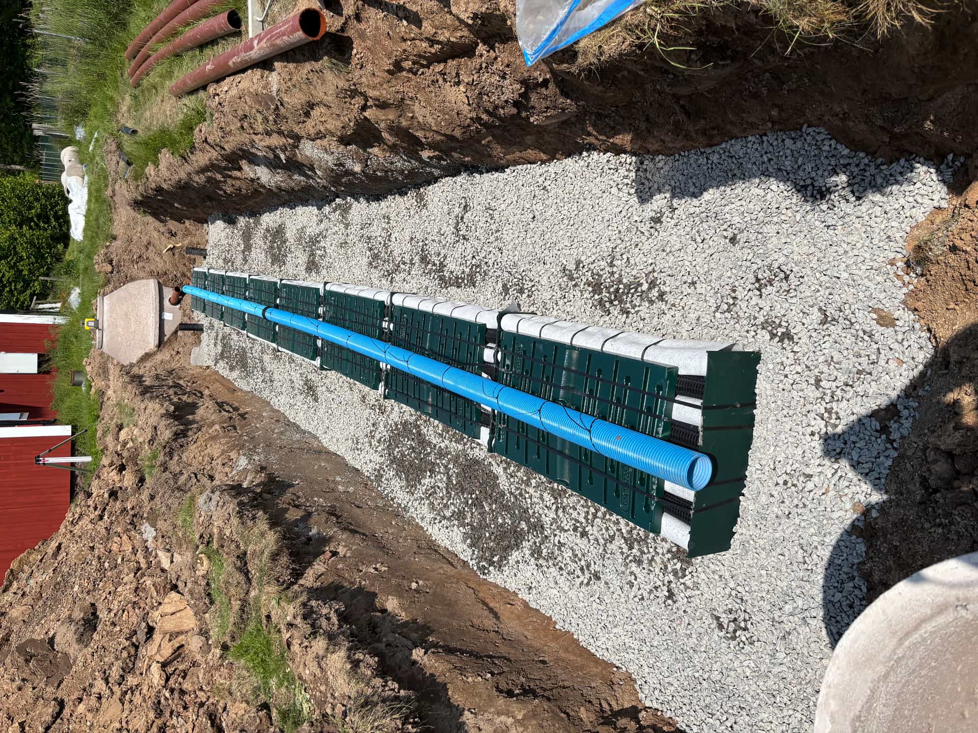 Gröna infiltrationsmoduler i schakt mot en betongbrunn