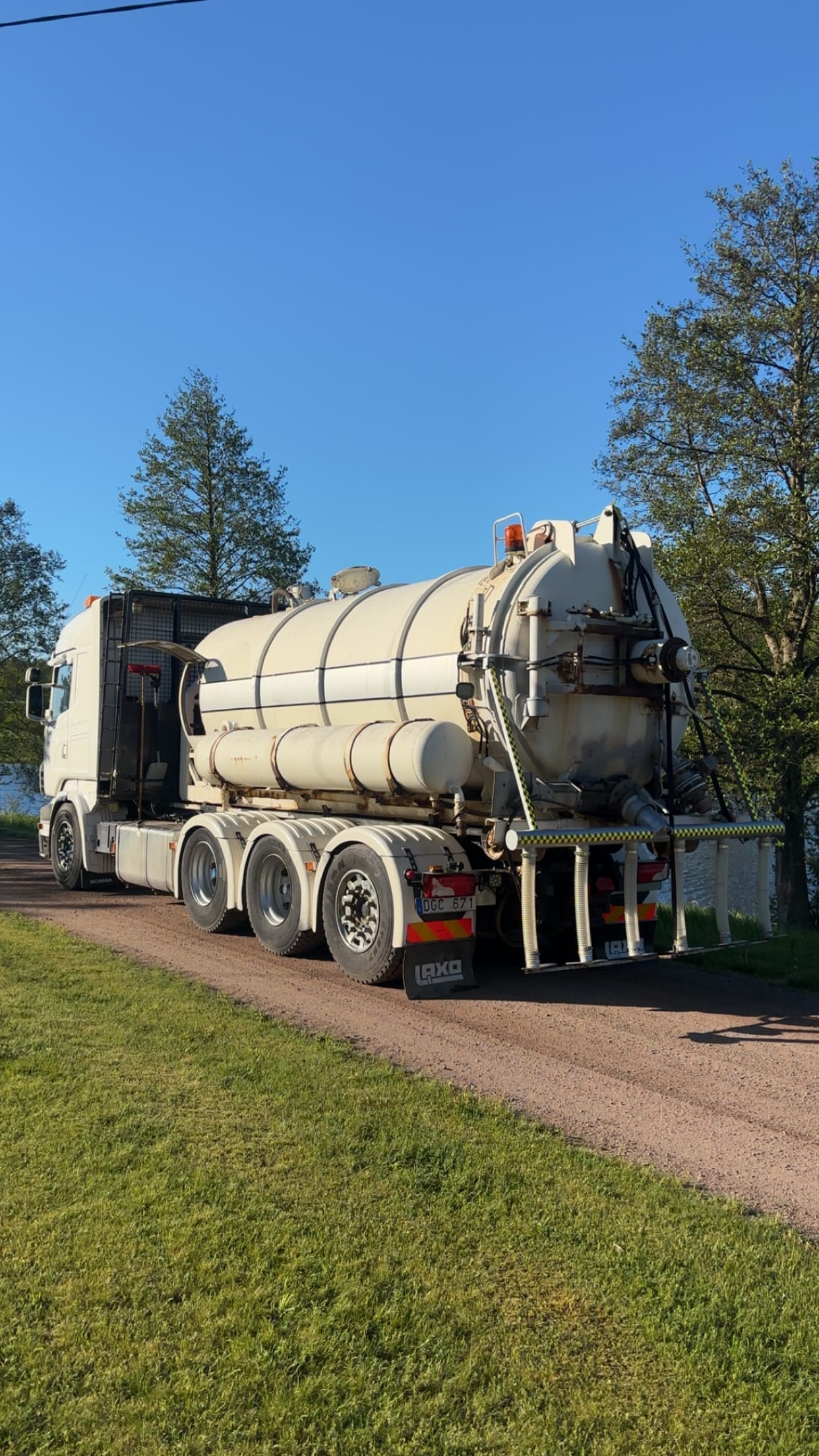Tankbil på en grusväg vid vatten